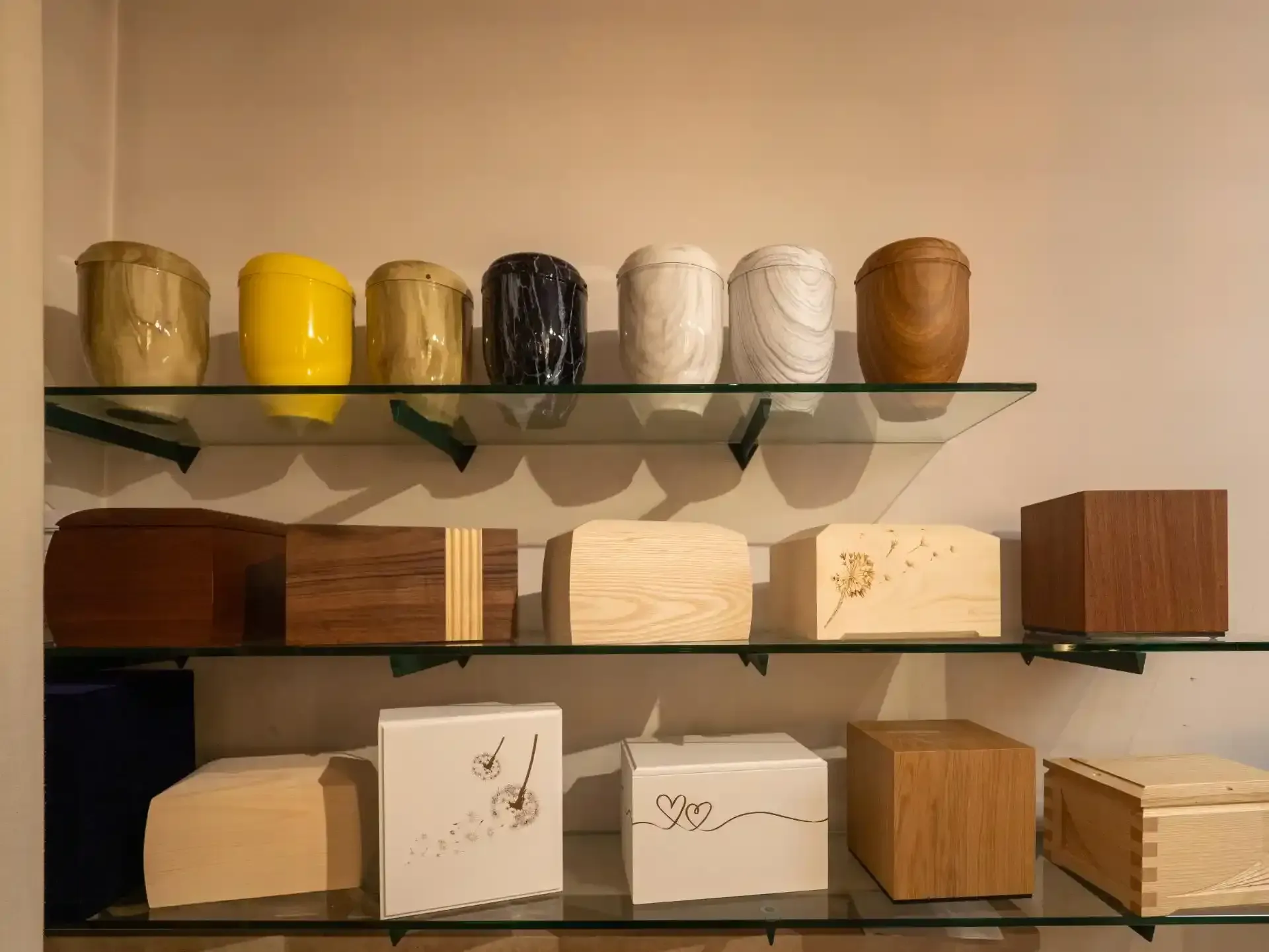 Scaffali che espongono varie urne cinerarie in un'agenzia di pompe funebri.