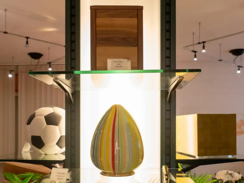 Vetrina con oggetti d'arte e una scultura raffigurante un pallone da calcio; illuminazione neutra.