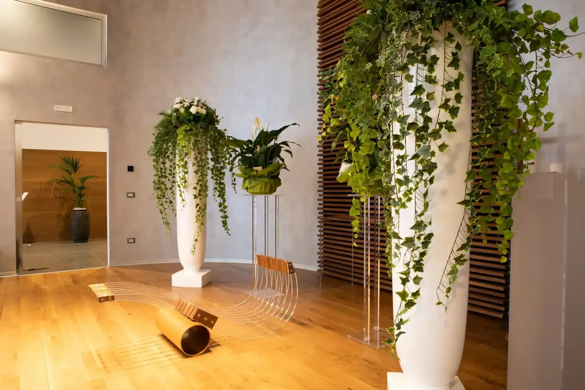 Elegante camera con pavimento in legno, colonne bianche e verde pensile.