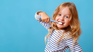 Little Girl in Striped Pajamas Is Brushing Her Teeth Little Girl in Striped Pajamas Is Brushing Her Teeth