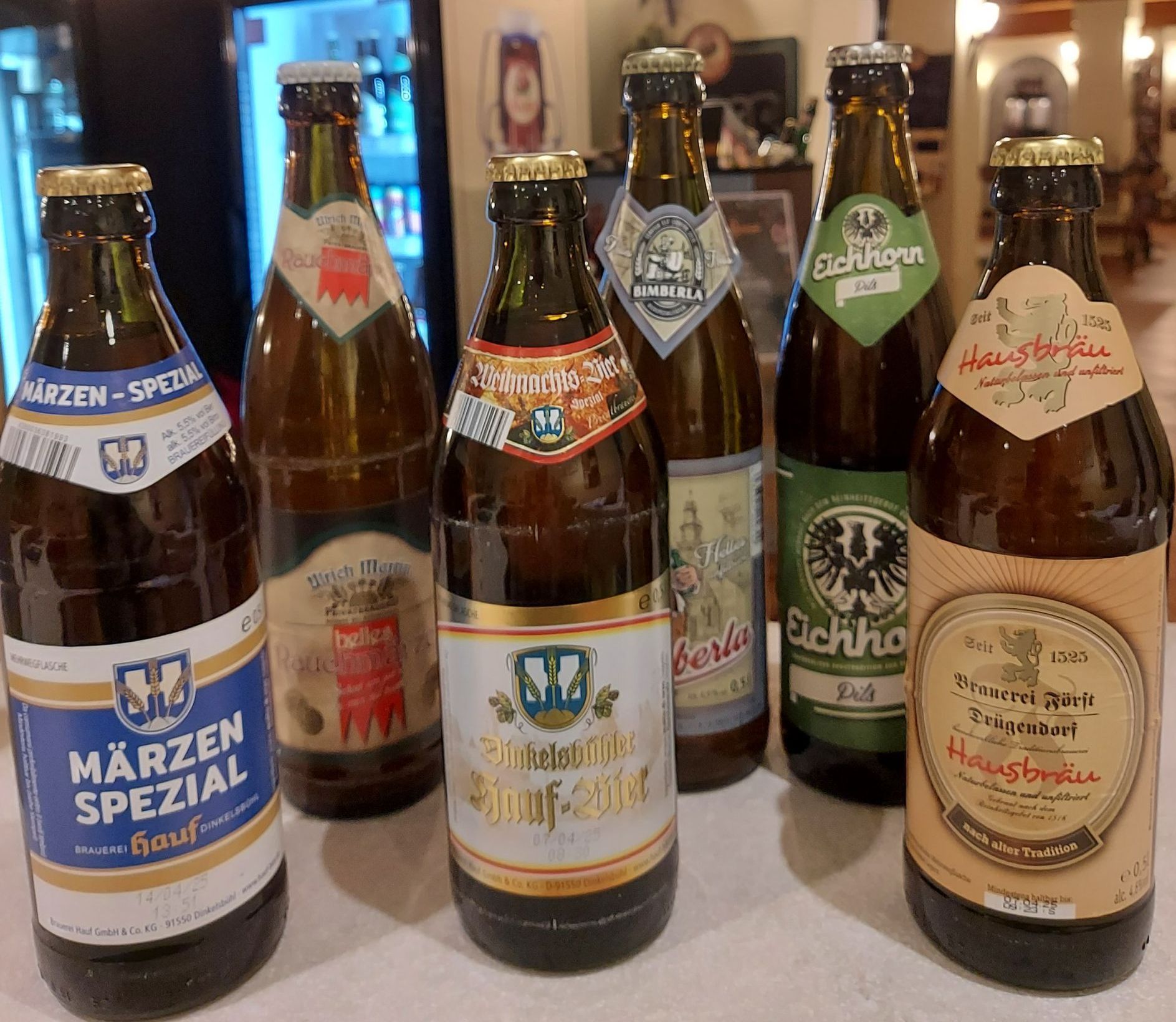 Un gruppo di bottiglie di birra sono appoggiate su un tavolo.