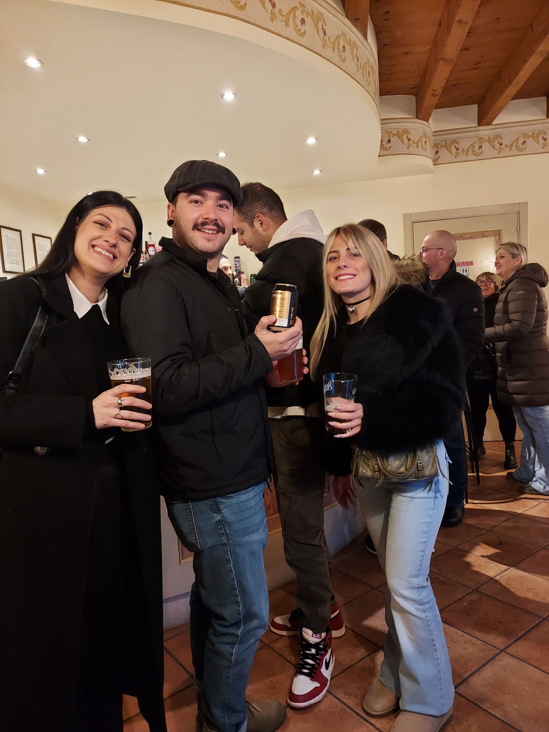Un gruppo di persone è in piedi in una stanza e tiene in mano dei drink.