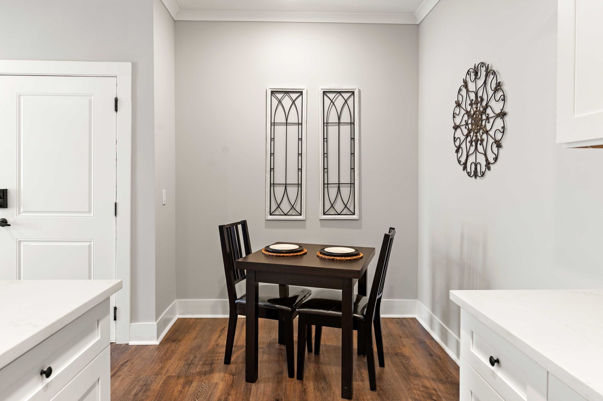 Apartment dining room with a table and chairs and a clock on the wall.