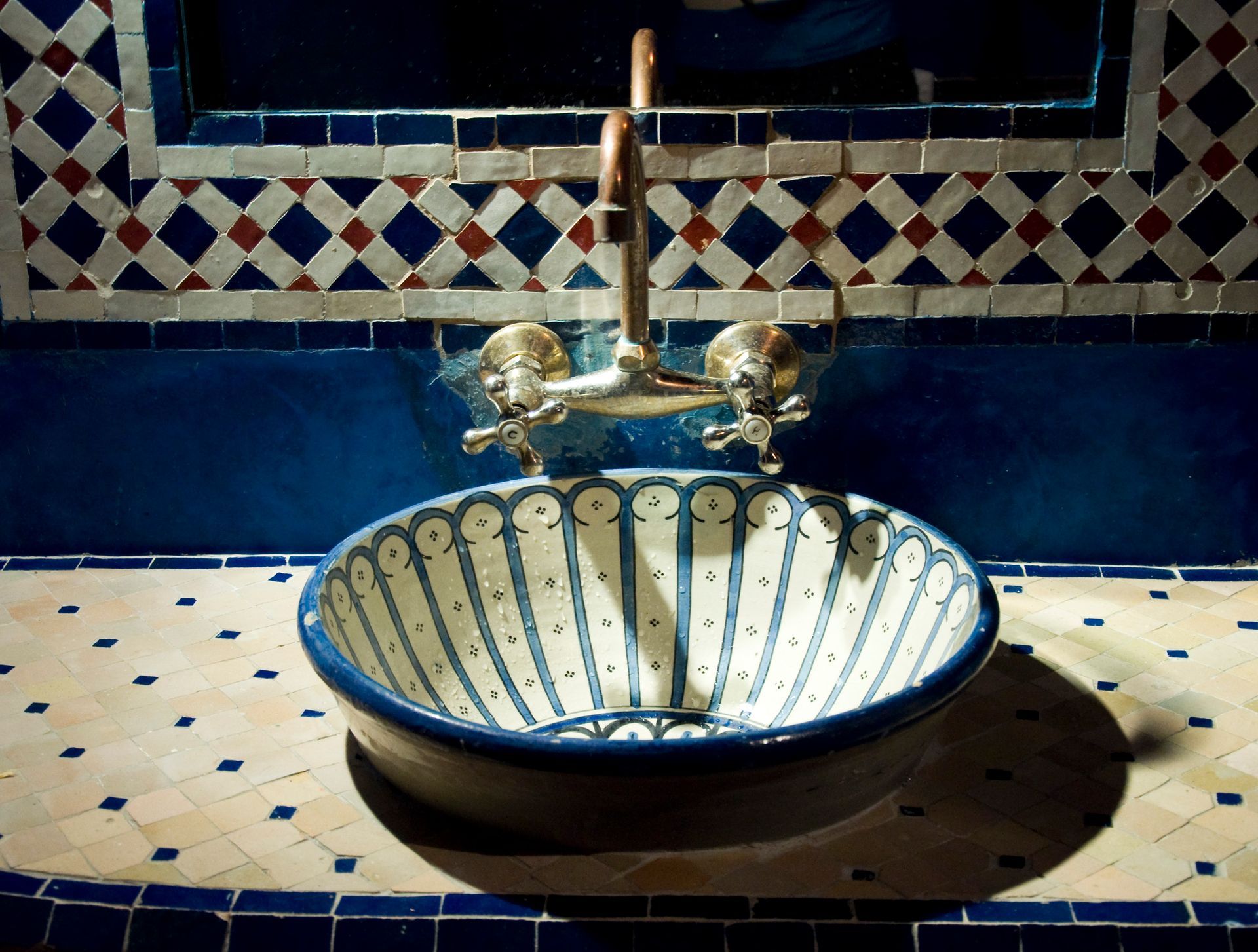 Un lavabo azul y blanco con grifo en un baño.
