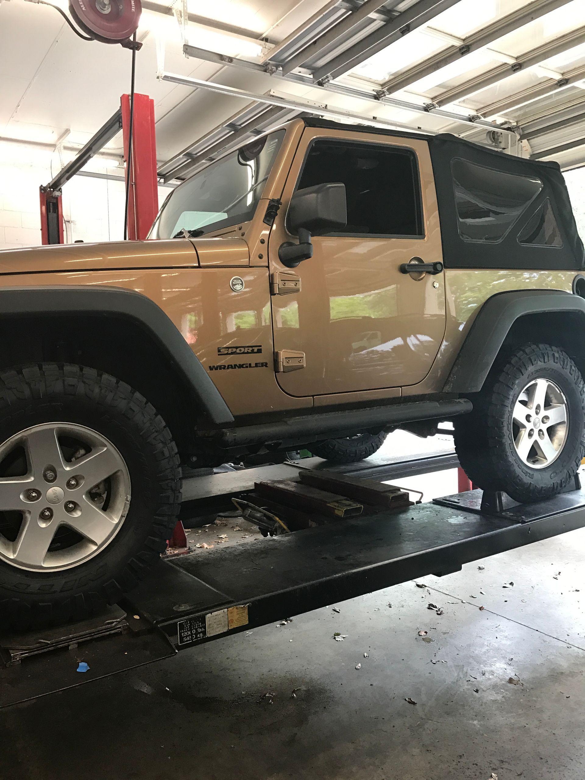 A Jeep is Sitting on a Lift in Our Repiar Shop in Jacksonville, FL - Mr. Best Wrench