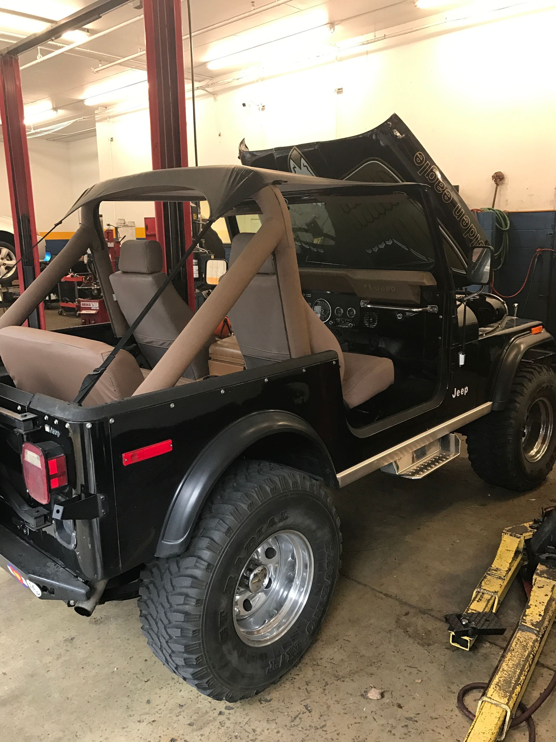 A Black Jeep is Parked in a Garage With the Hood Up - Mr. Best Wrench