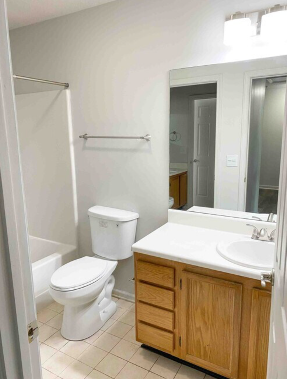 A bathroom with a toilet , sink , and mirror.