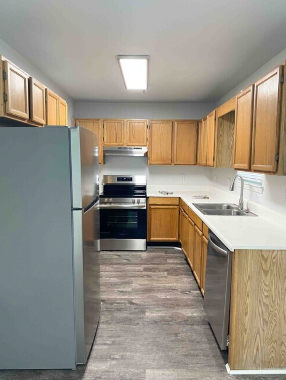 A kitchen with stainless steel appliances and wooden cabinets.