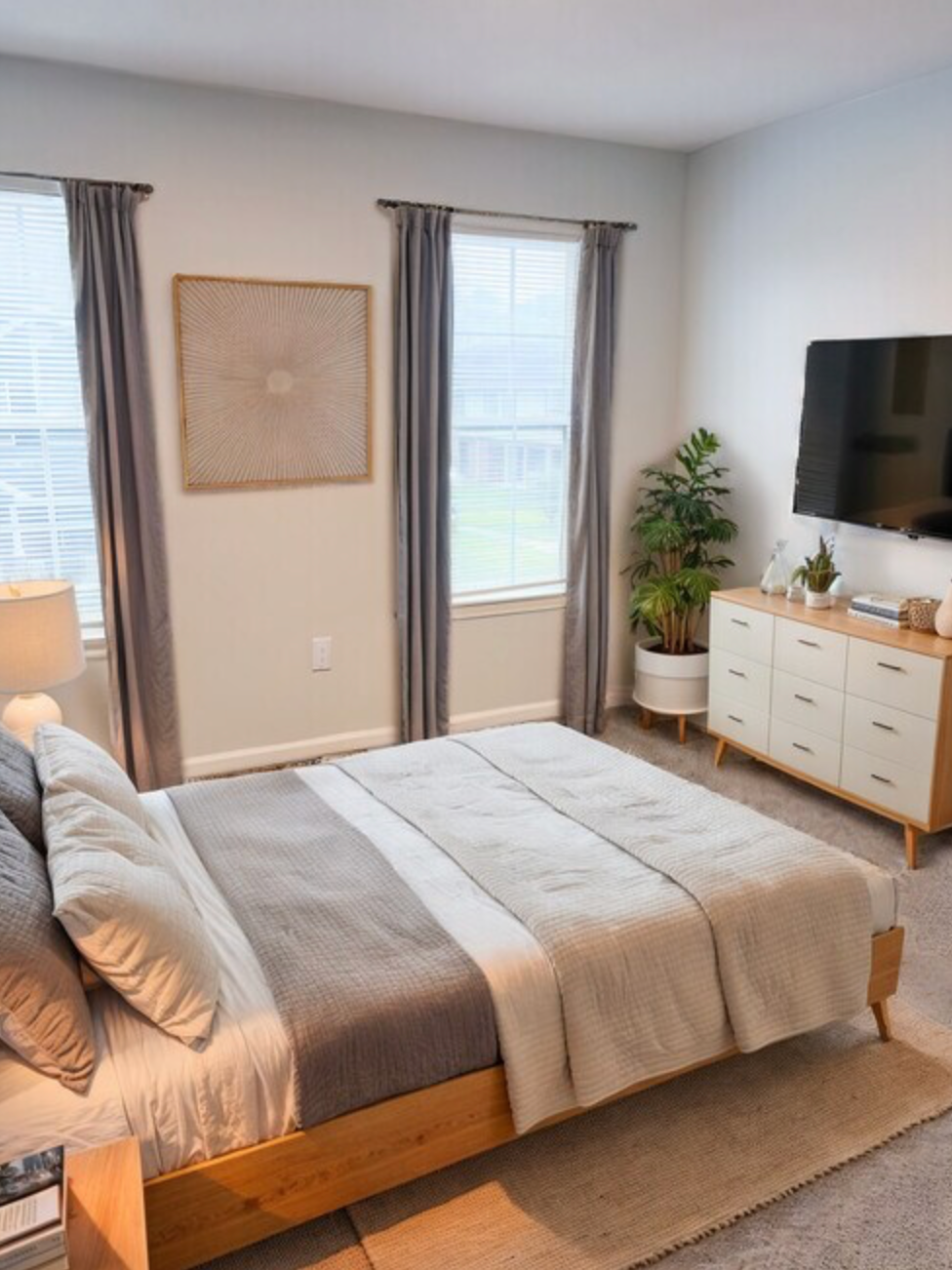 A bedroom with a large bed , dresser , and television.