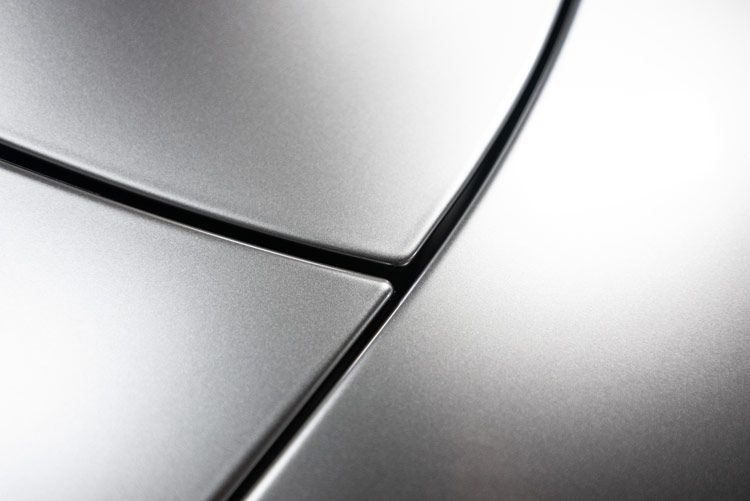 A close up of a silver car door with a black trim.