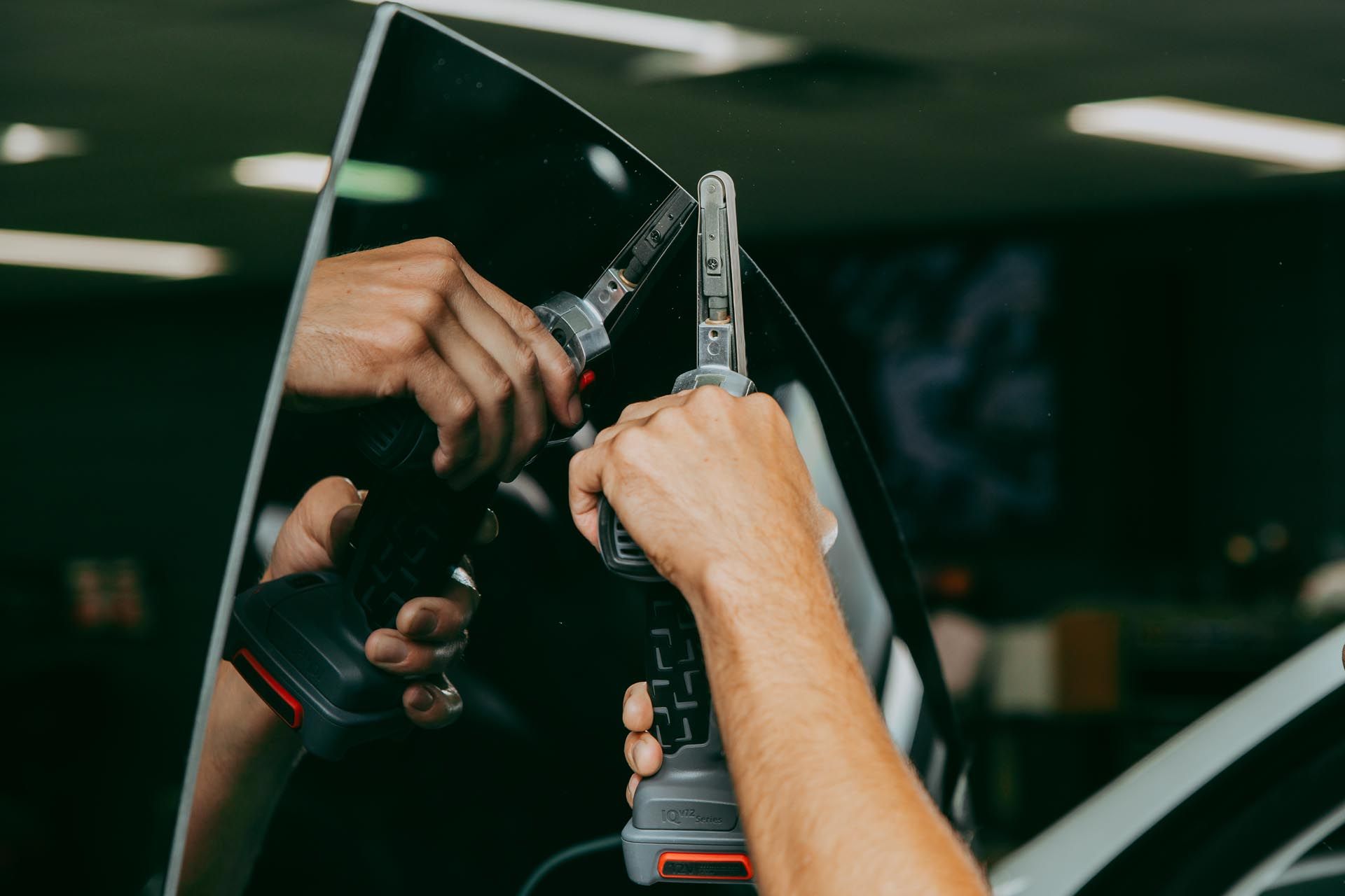 A person is installing window tinting on a car window.