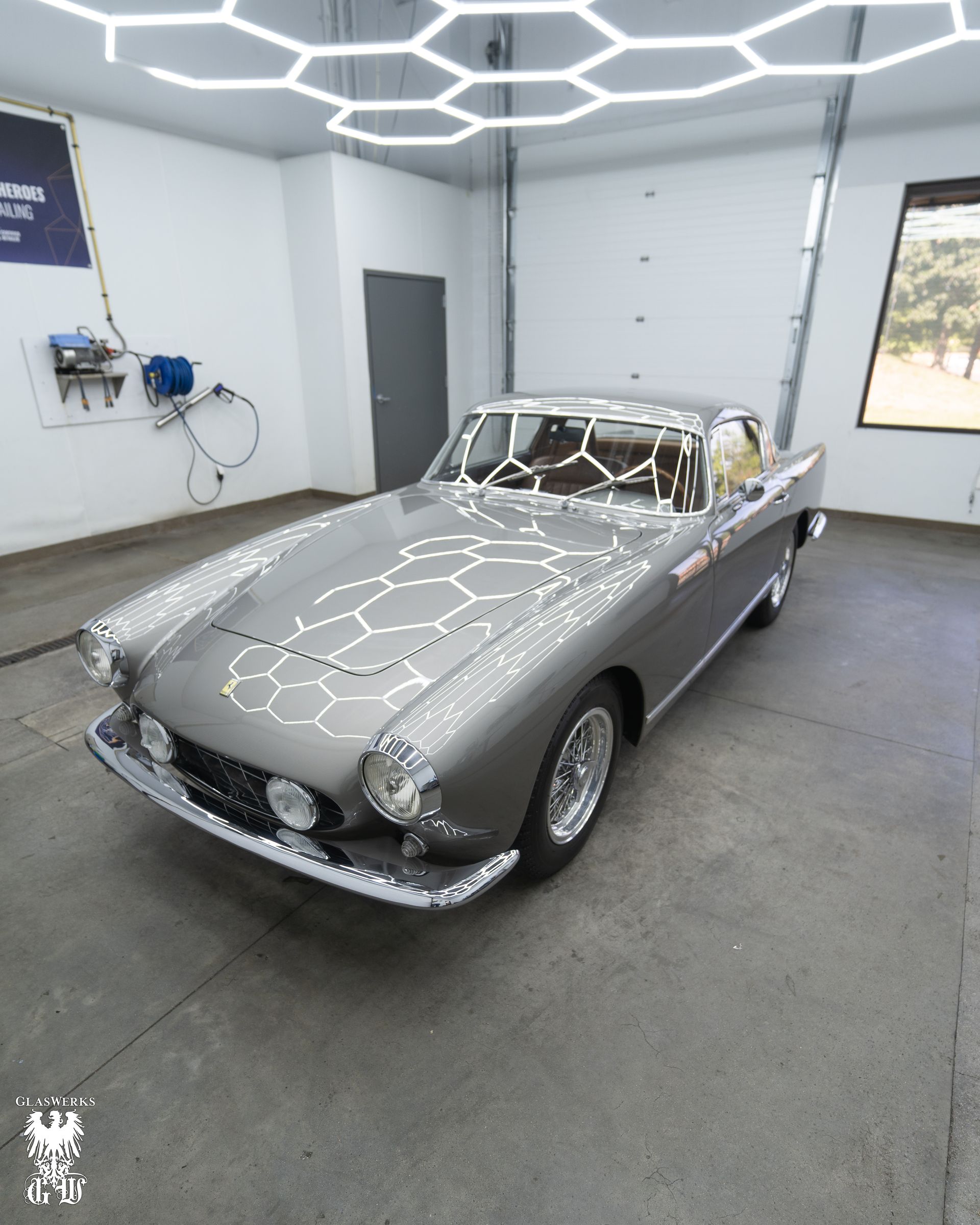 A gray car is parked in a garage.