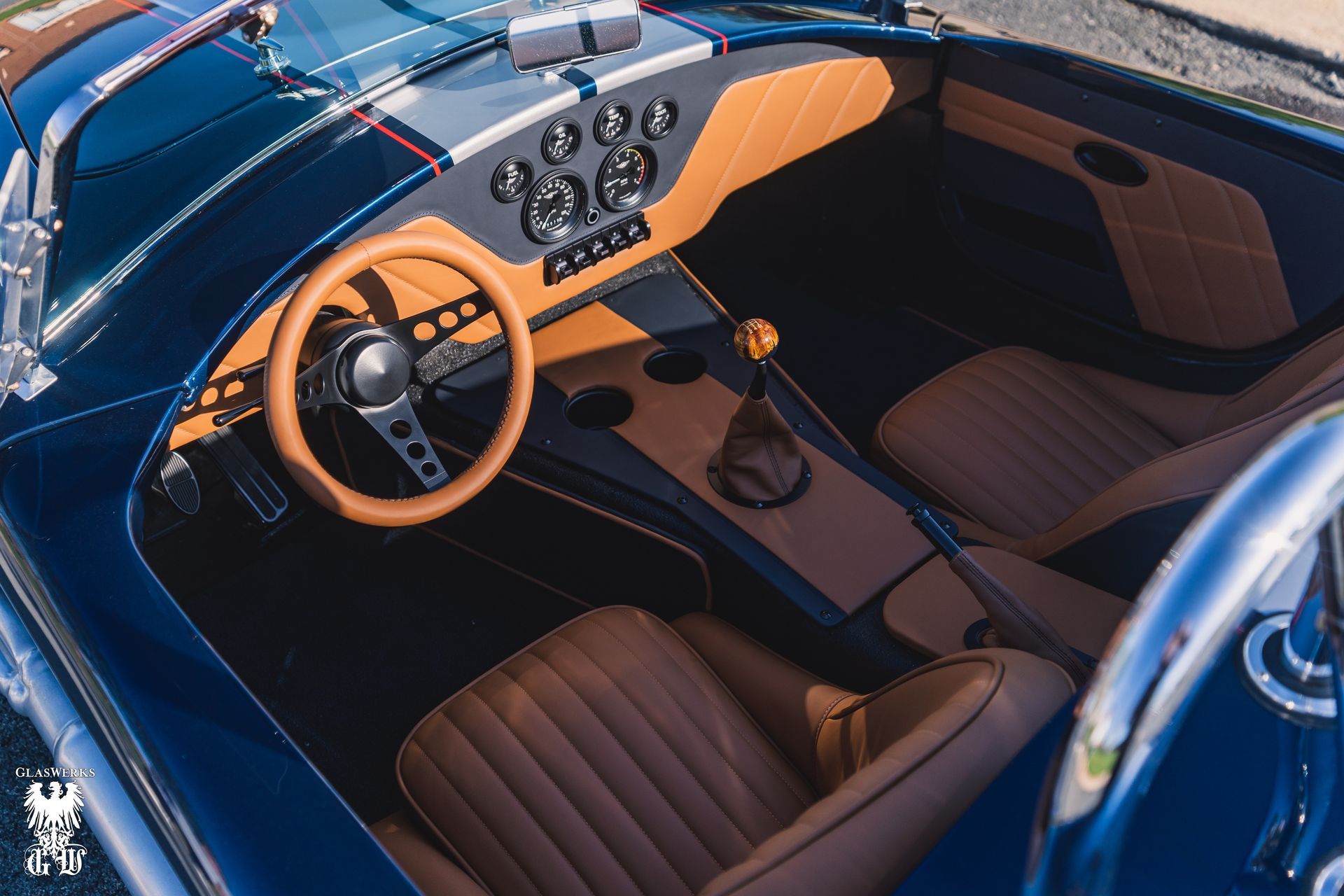 A close up of a porsche wheel with orange brake calipers