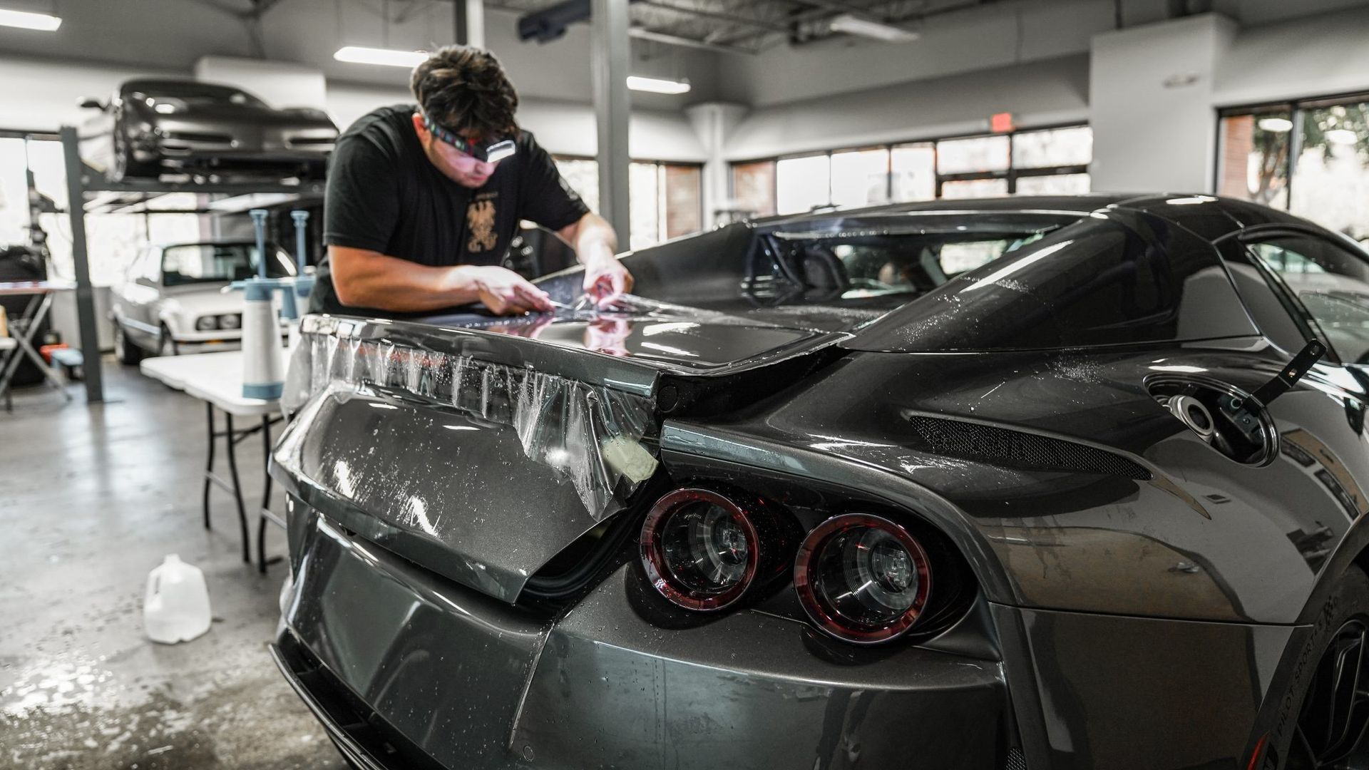 A gray porsche 911 turbo is parked in a garage.