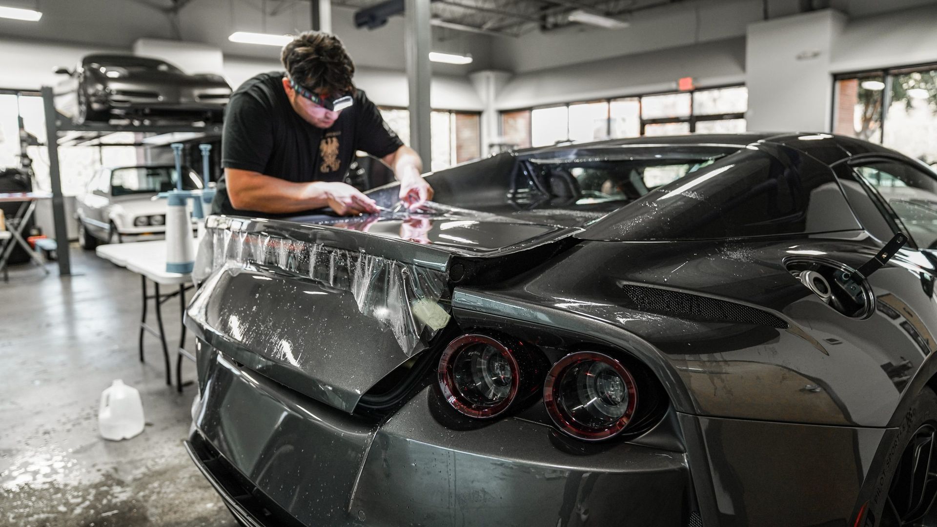 A man is working on a car in a garage.