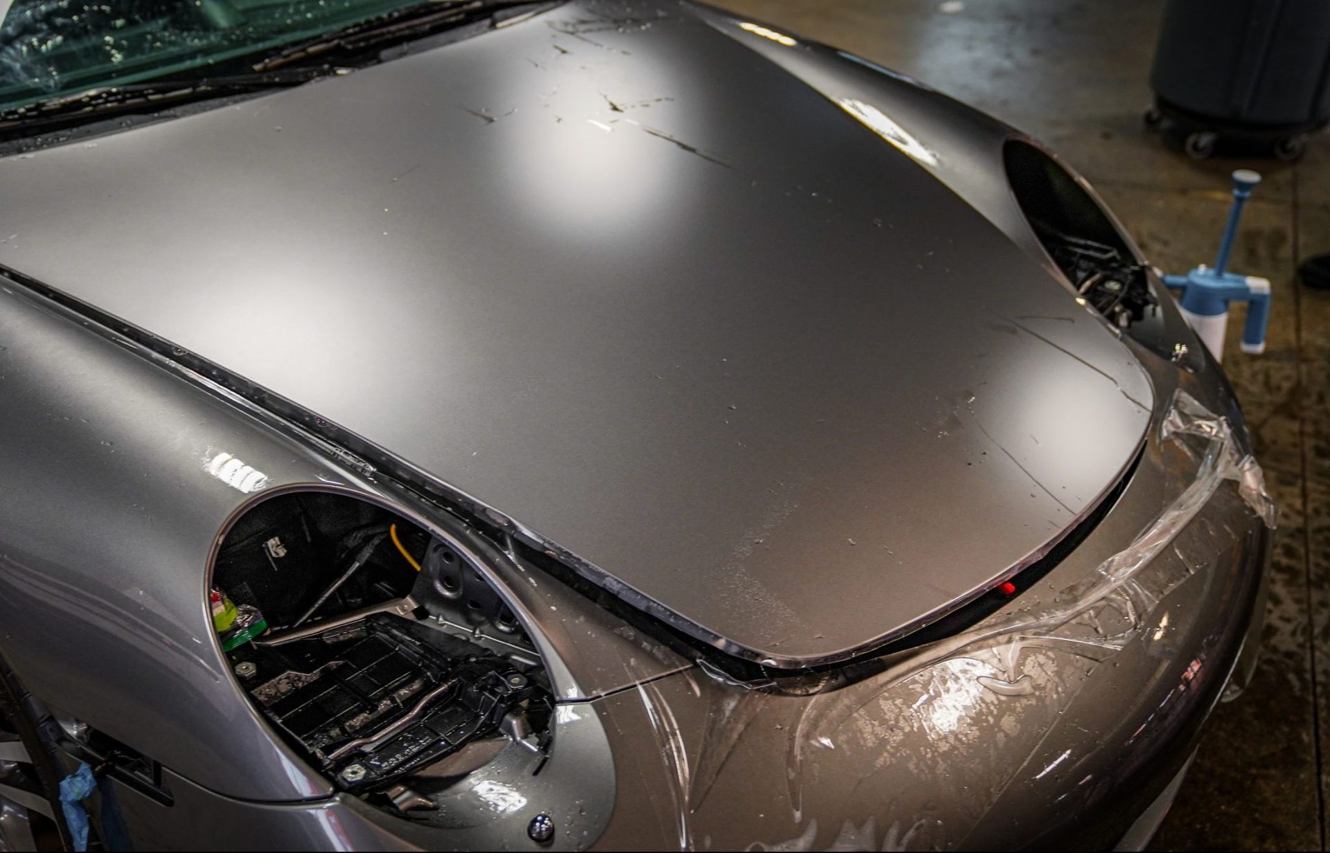 The hood of a car is covered in plastic wrap.