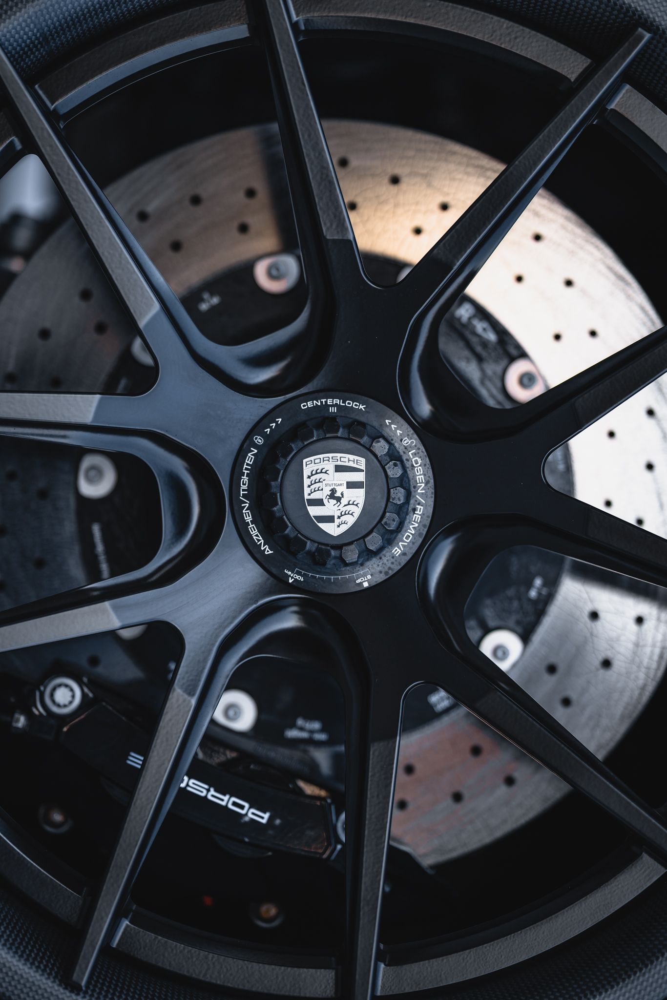 A close up of a porsche wheel with a brake disc.