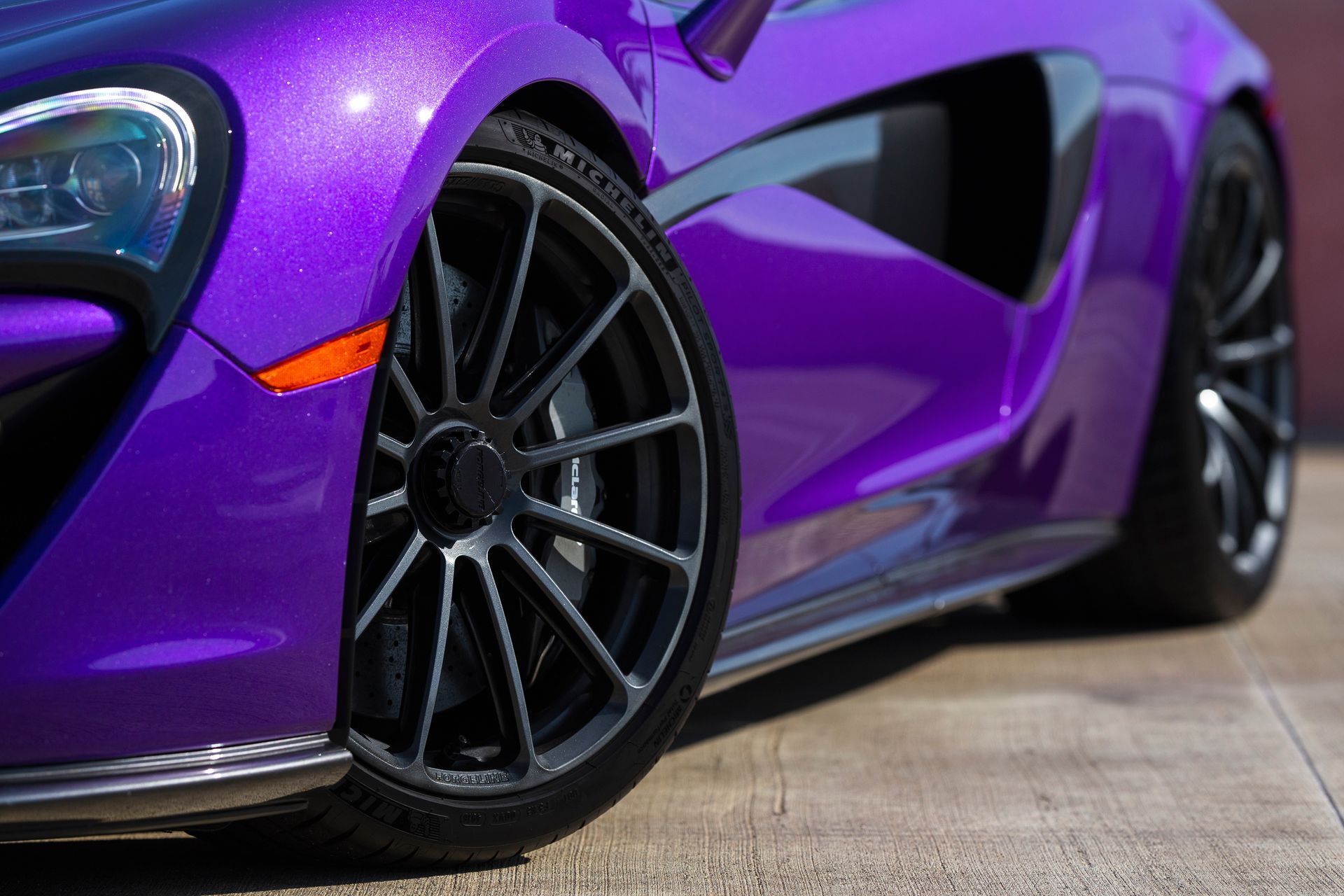 A purple sports car is parked on the side of the road.