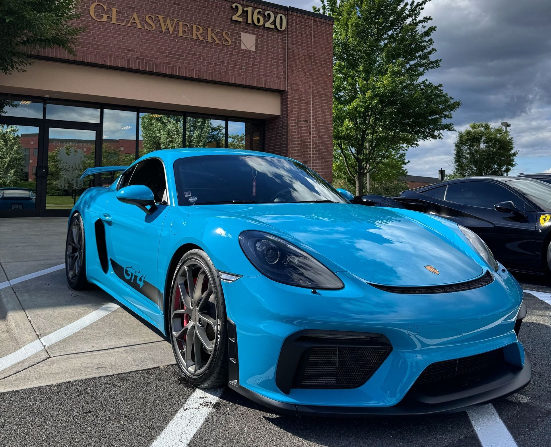 Hands applying film to a dark blue car's vents.