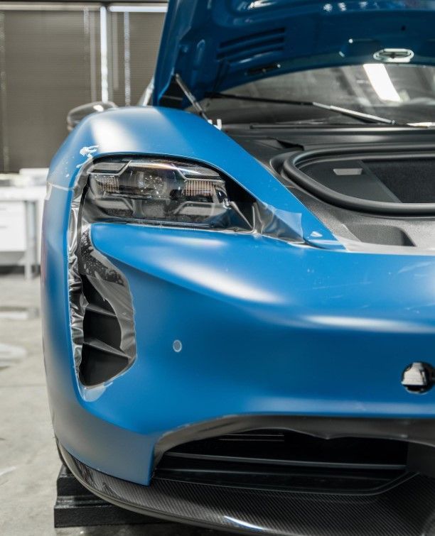 A close up of a blue sports car with the hood up