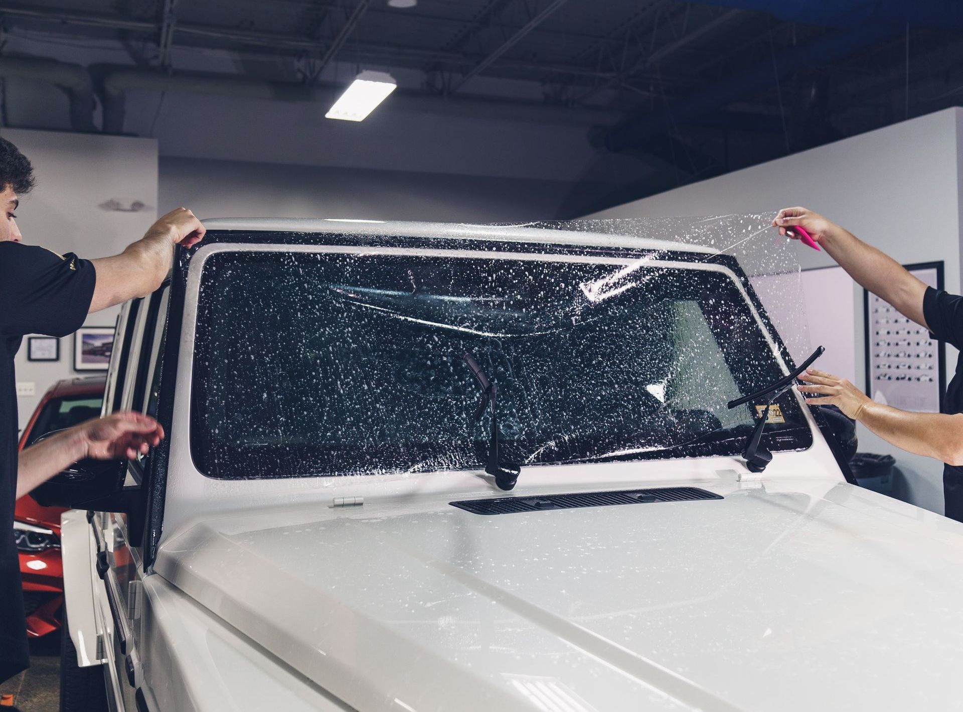 A person is working on the hood of a car.