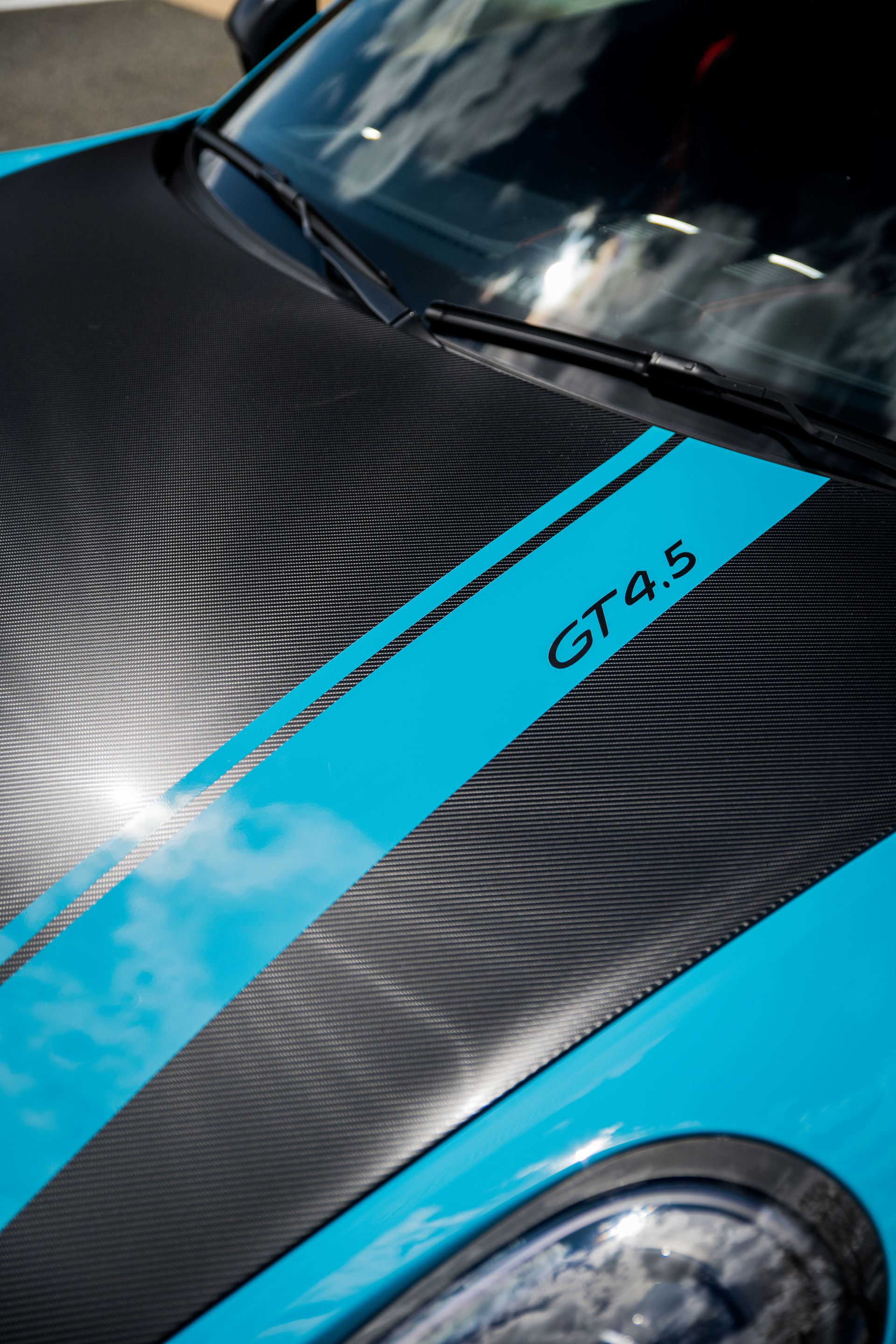 A blue car with a black hood and a blue stripe that says gt45