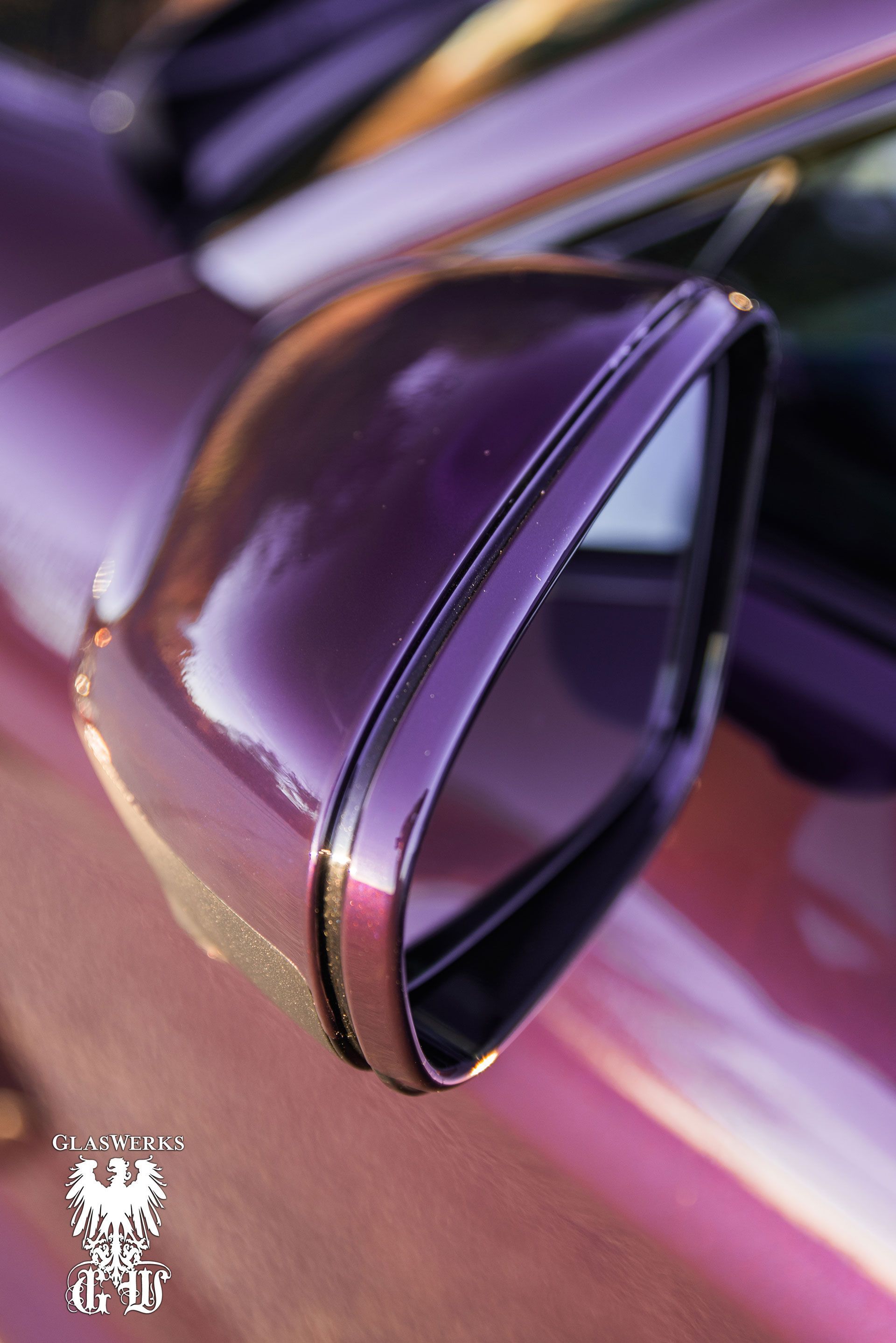 A close up of a purple car 's side mirror