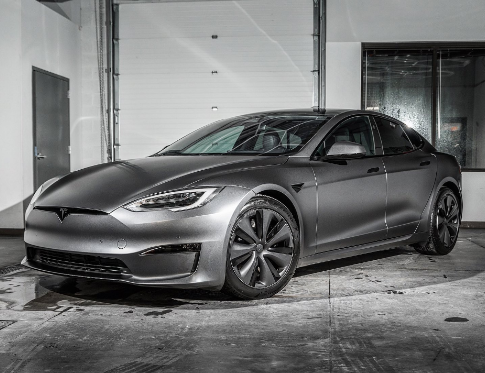 A tesla model s is parked in a garage.