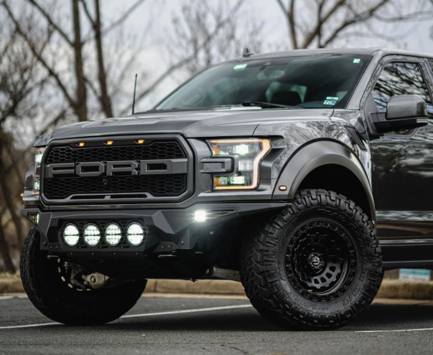 A ford raptor truck is parked on the side of the road.