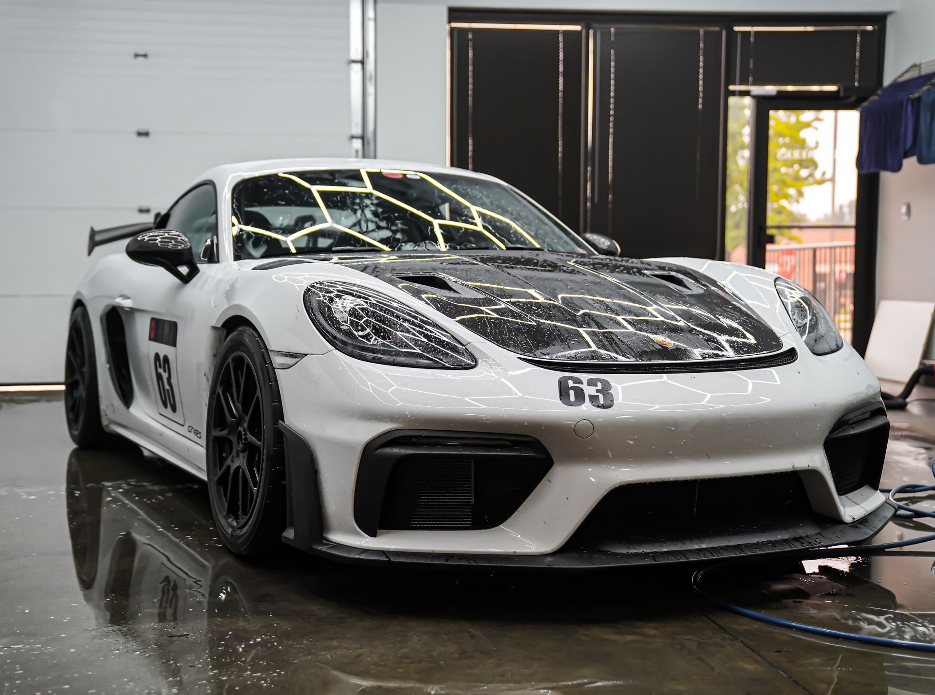 A car is covered in foam in a garage.