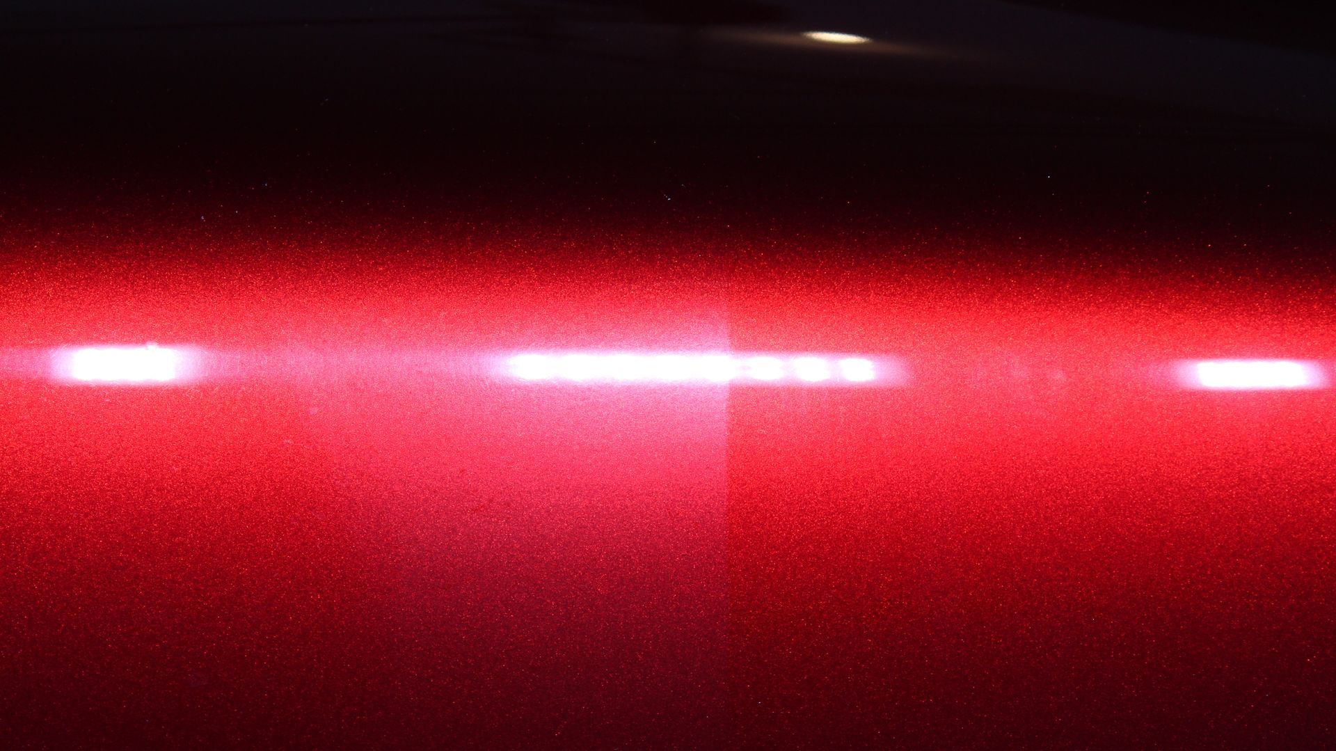 A close up of a red car with a black background.