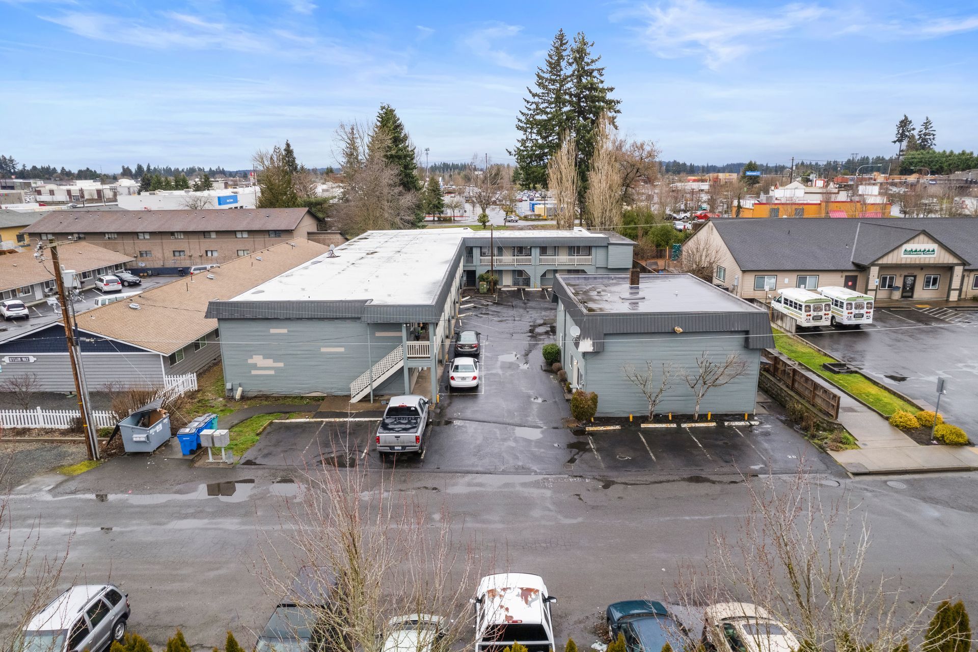 An aerial view of a parking lot with cars parked in front of a building.