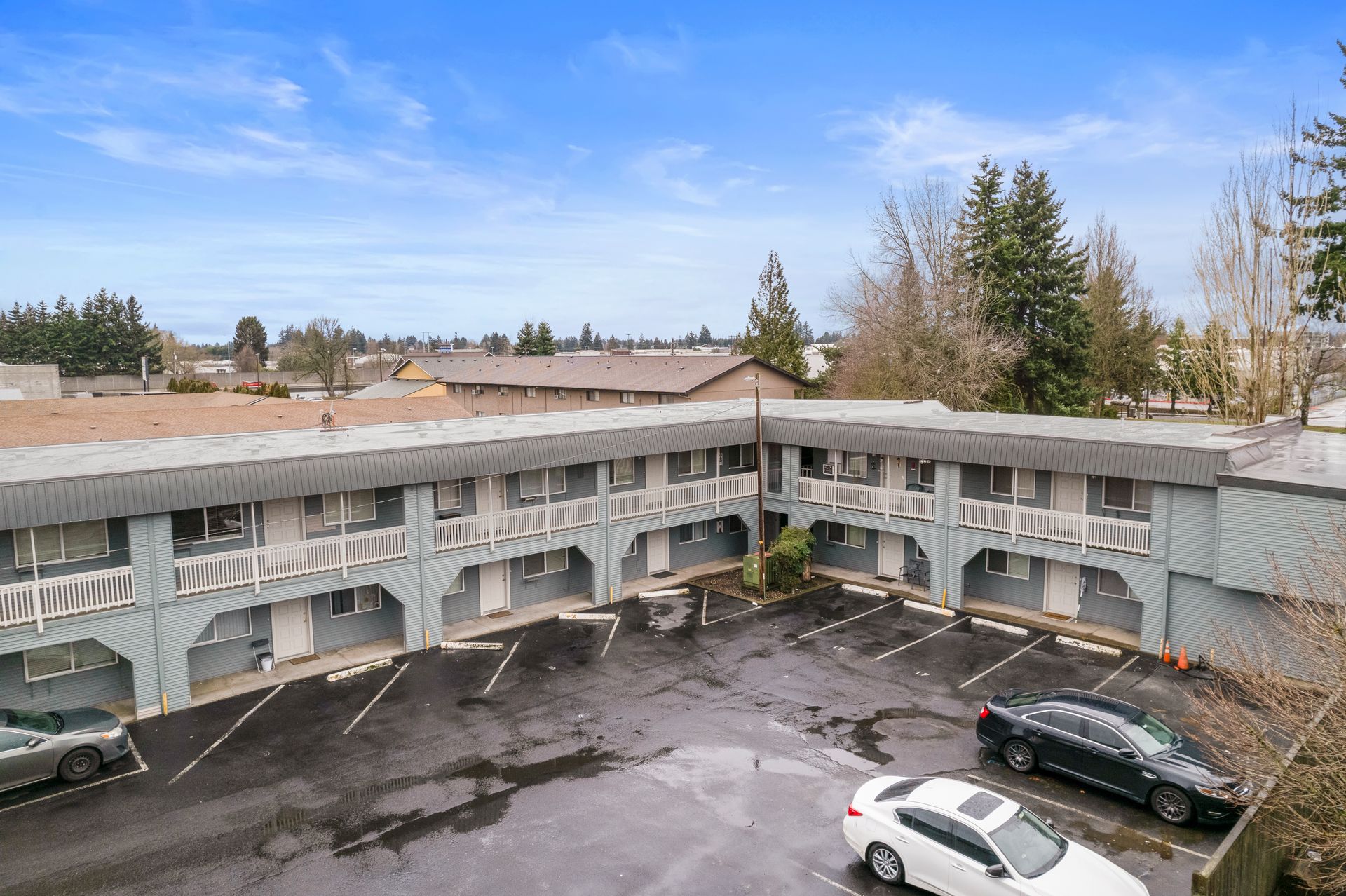 An aerial view of a hotel with cars parked in front of it.