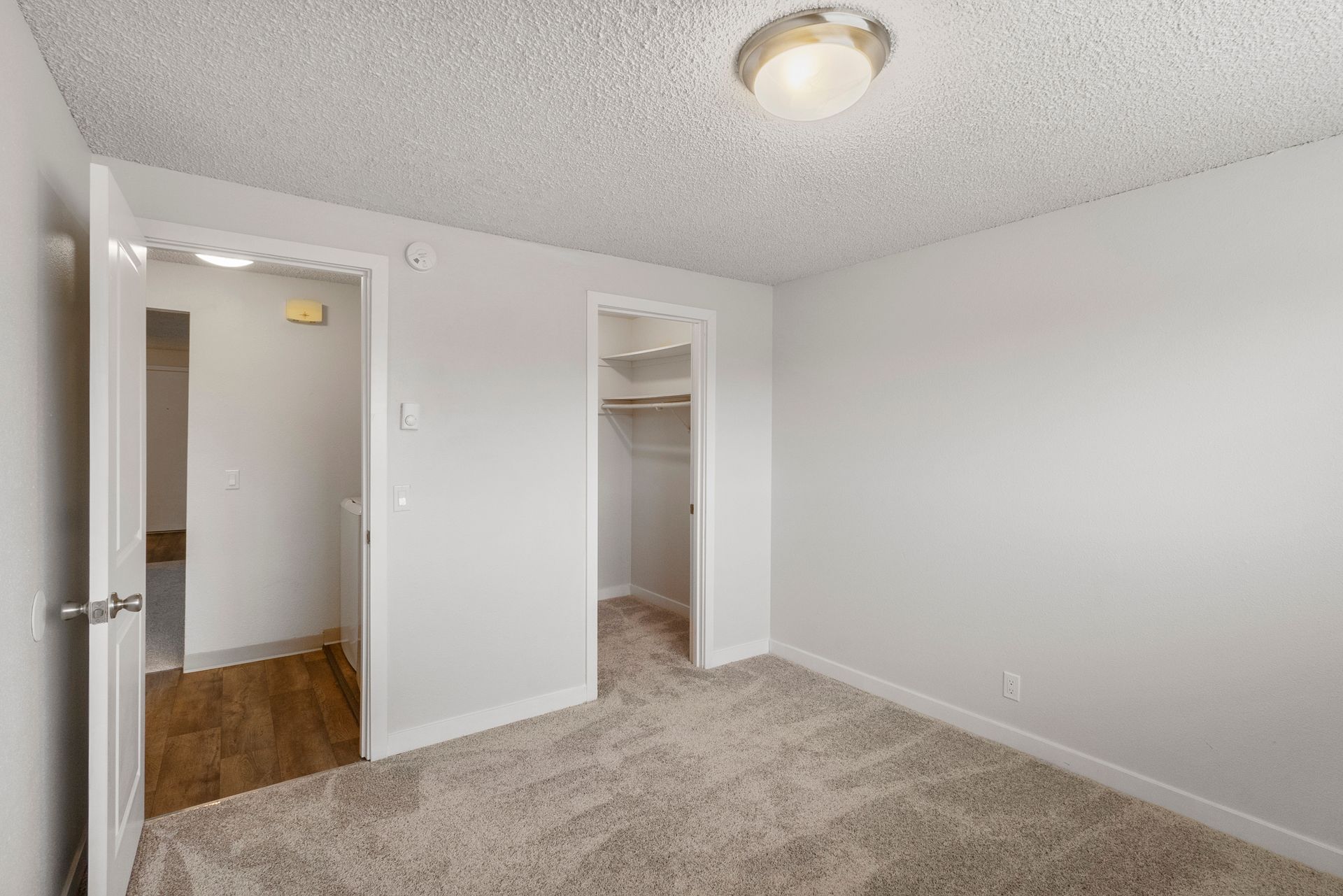 An empty bedroom with a walk in closet and a bathroom.