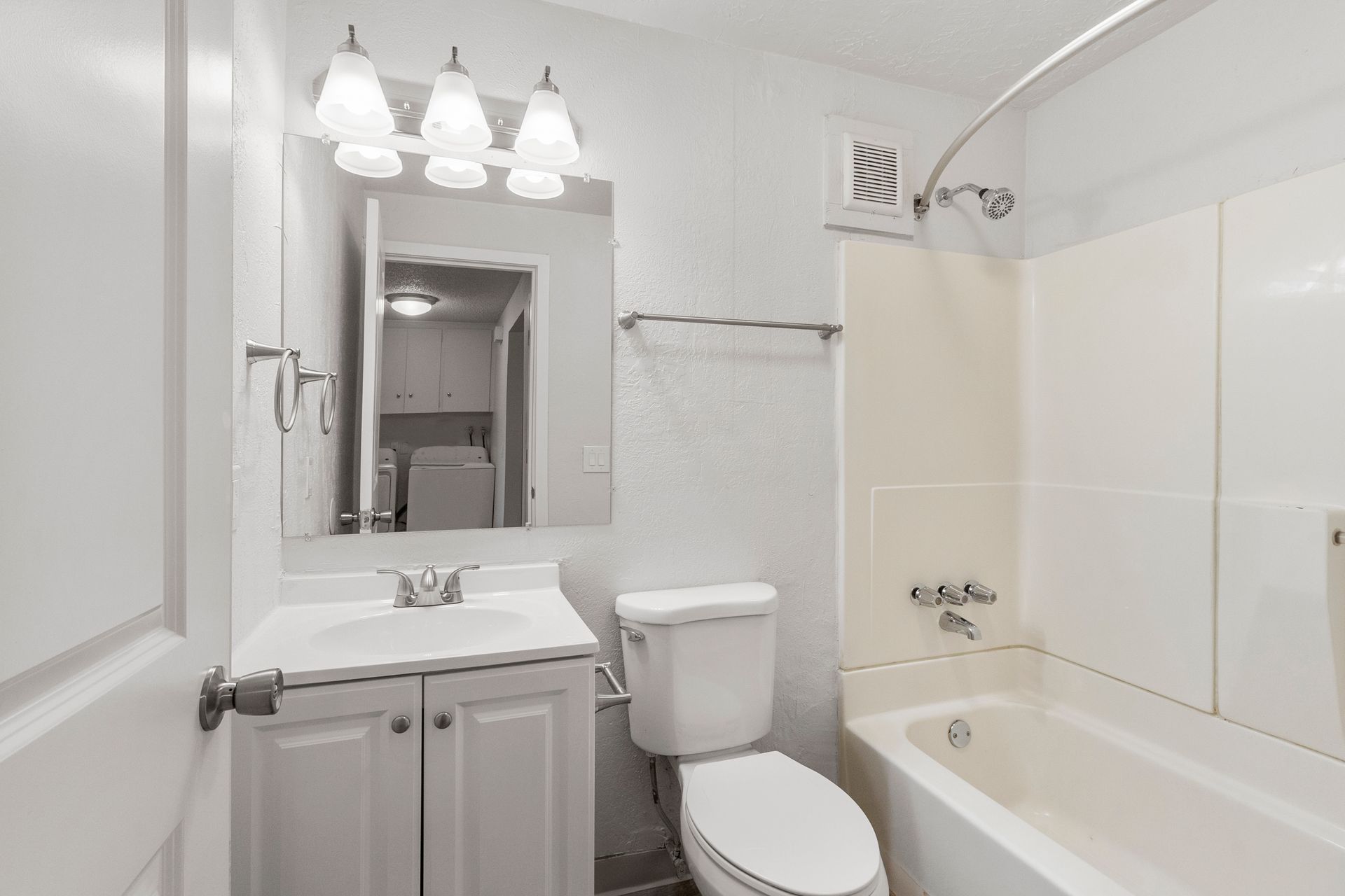 A bathroom with a toilet , sink , and bathtub.