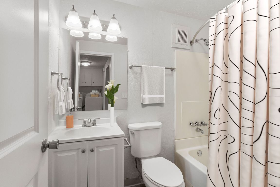 A bathroom with a toilet , sink , and bathtub.