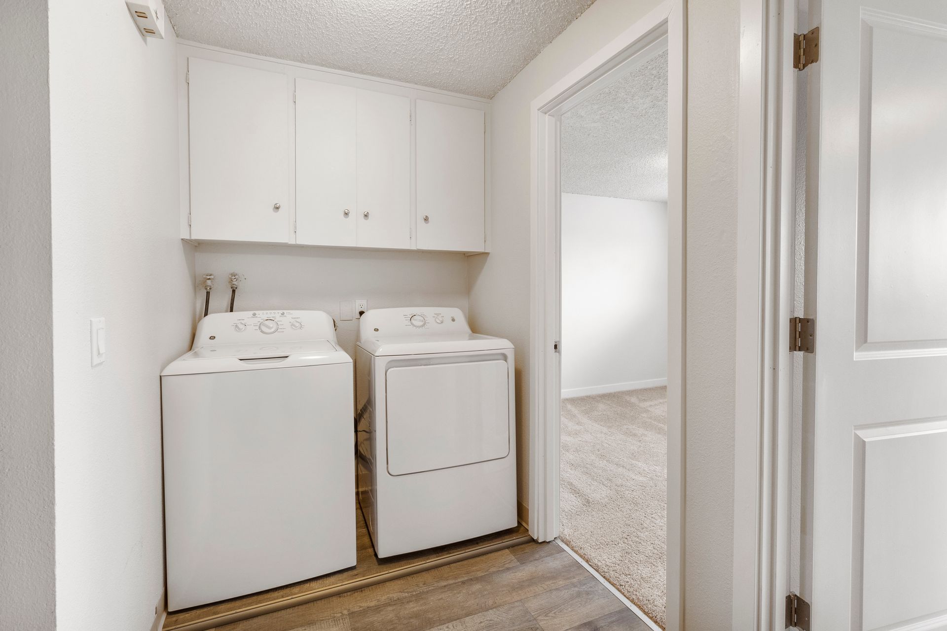 A laundry room with a washer and dryer in a house.
