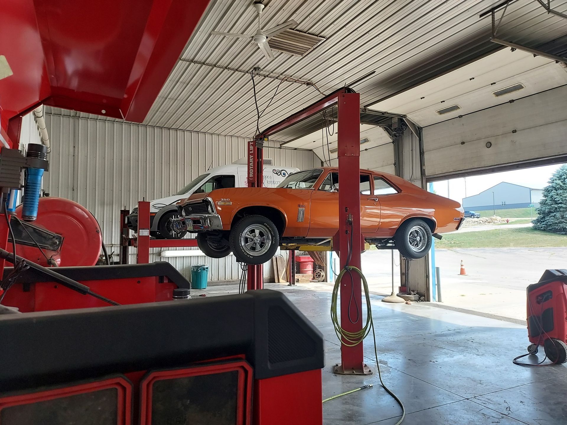 Orange Classic Car on a Lift in a Garage | Kerp's Service Center