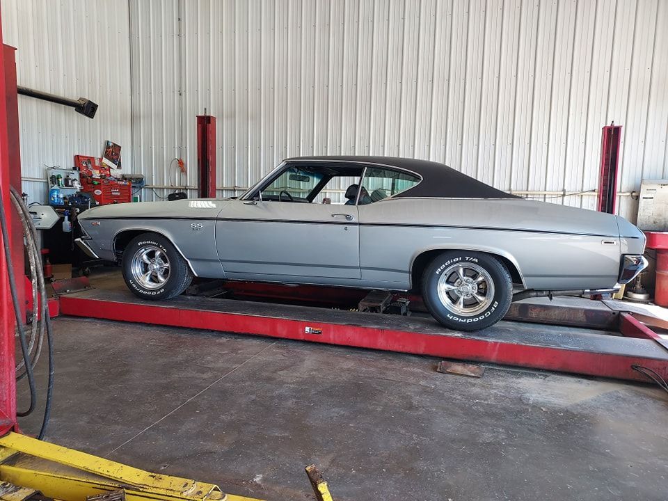 Silver classic Chevrolet Chevelle on a lift inside a repair shop | Kerp's Service Center