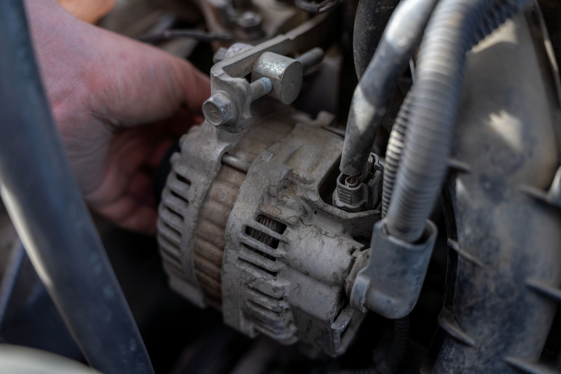Hand working on a dirty car alternator. Hand working on a dirty car alternator.