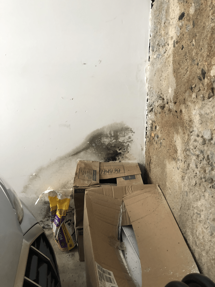 A pile of cardboard boxes sitting next to a wall.