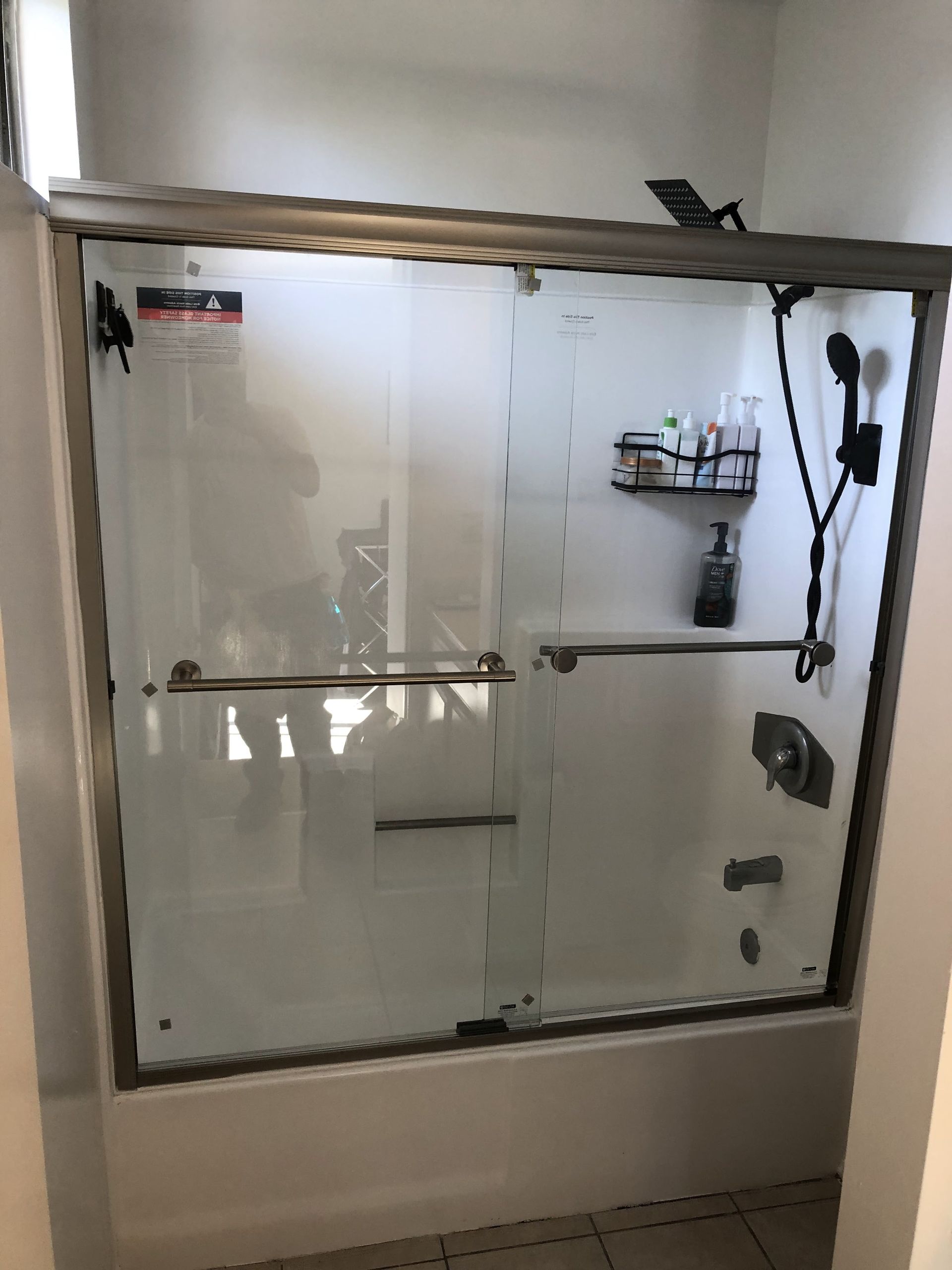 A bathroom with a sliding glass shower door