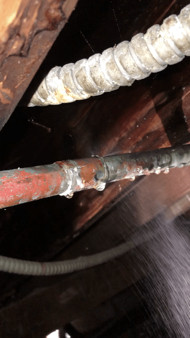 A close up of a rusty pipe with water coming out of it.