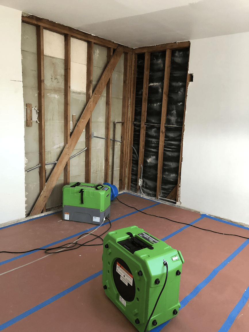 A green box is sitting in a room next to a wall.