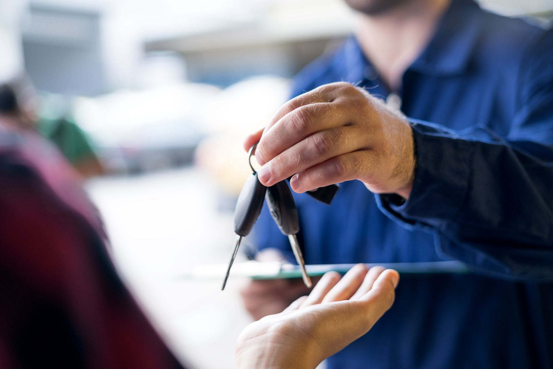 A man is handing a car key to a woman.