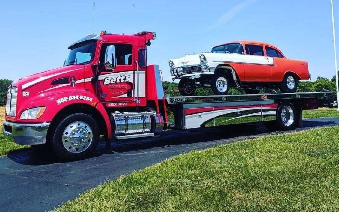 Betts Garage flatbed hauling vintage car on a sunny day