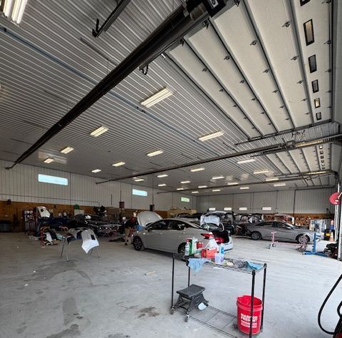 Interior view of B&G Auto Body workshop ceiling with lighting and garage doors