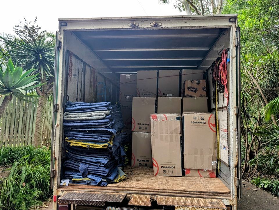 The Back of a Moving Truck Filled With Boxes and Blankets — Little Green Truck Port Macquarie in Laurieton, NSW