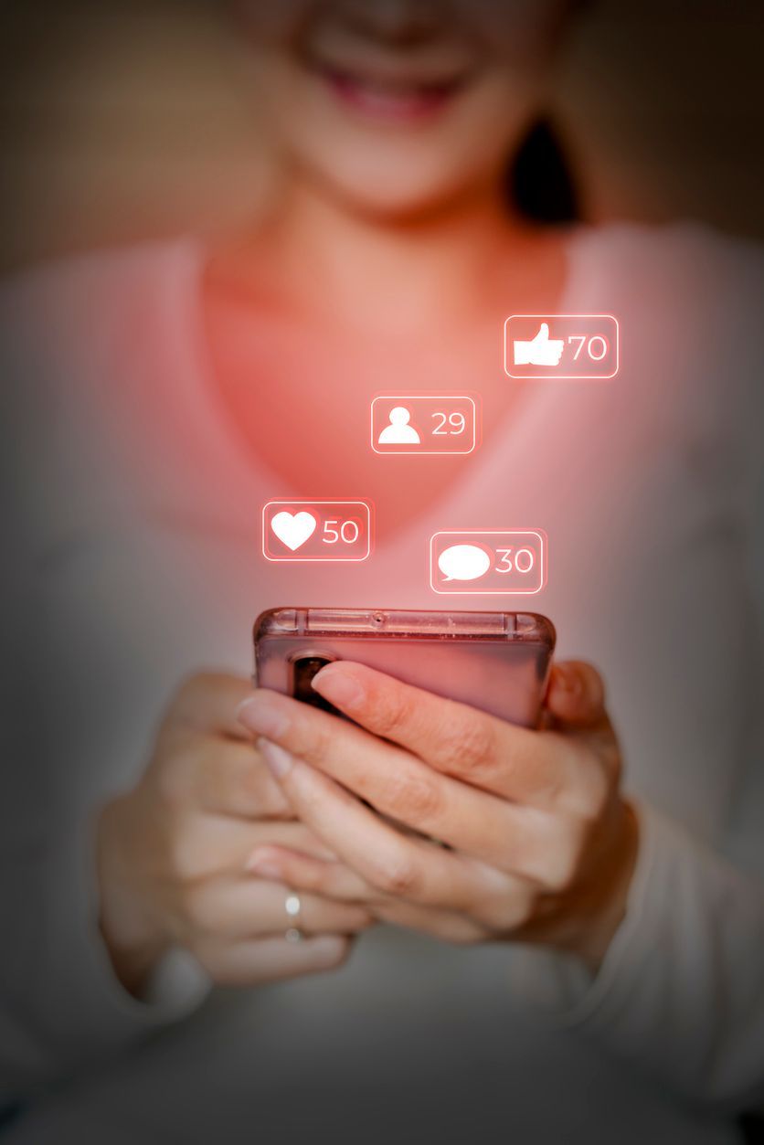 A woman is holding a cell phone in her hands.