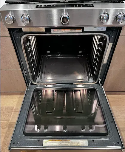 Open oven with stainless steel frame, black interior, and glass door.
